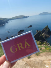 Load image into Gallery viewer, Grá – Love Irish fridge magnet held up over the Kerry coastline
